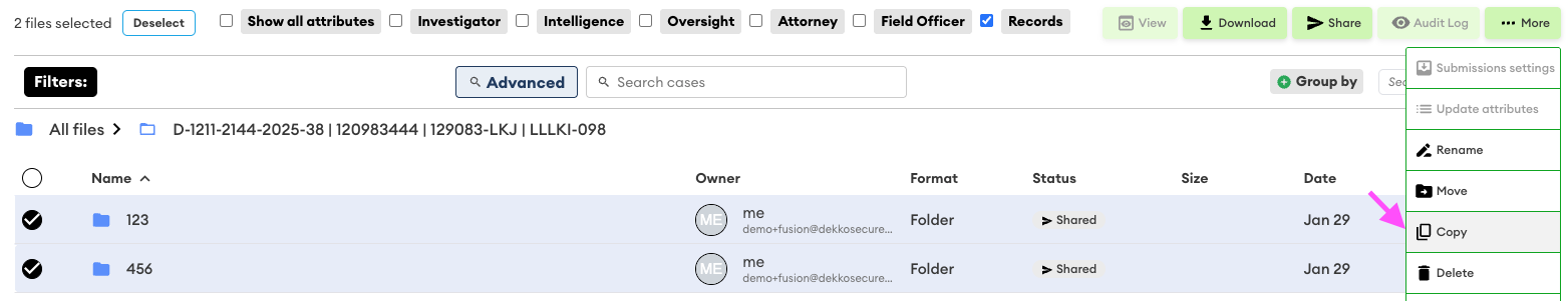 Two folders selected with the More menu open, showing the Copy option highlighted by a pink arrow.
